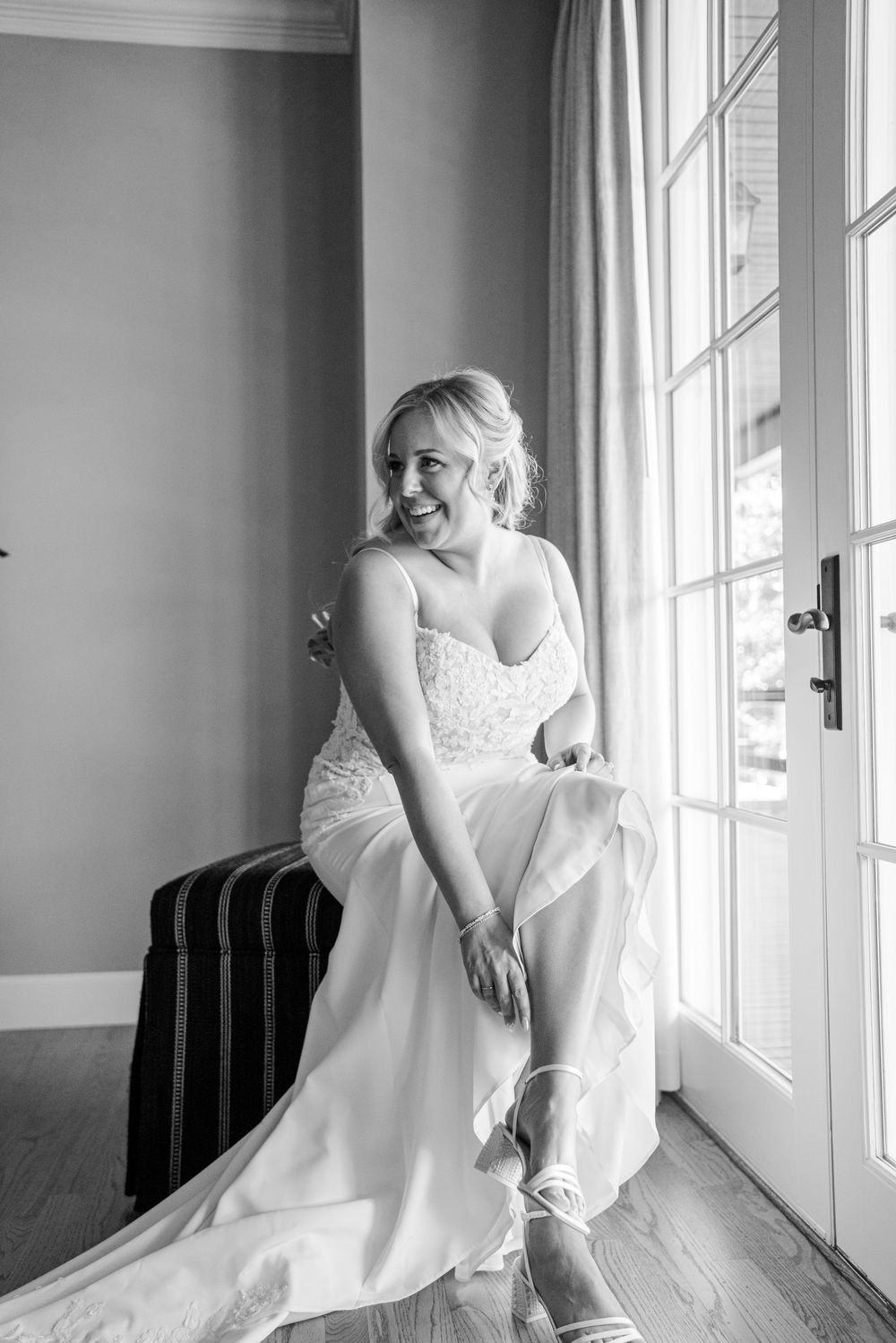 Artistic black and white photos showing details of a white wedding dress near large windows.