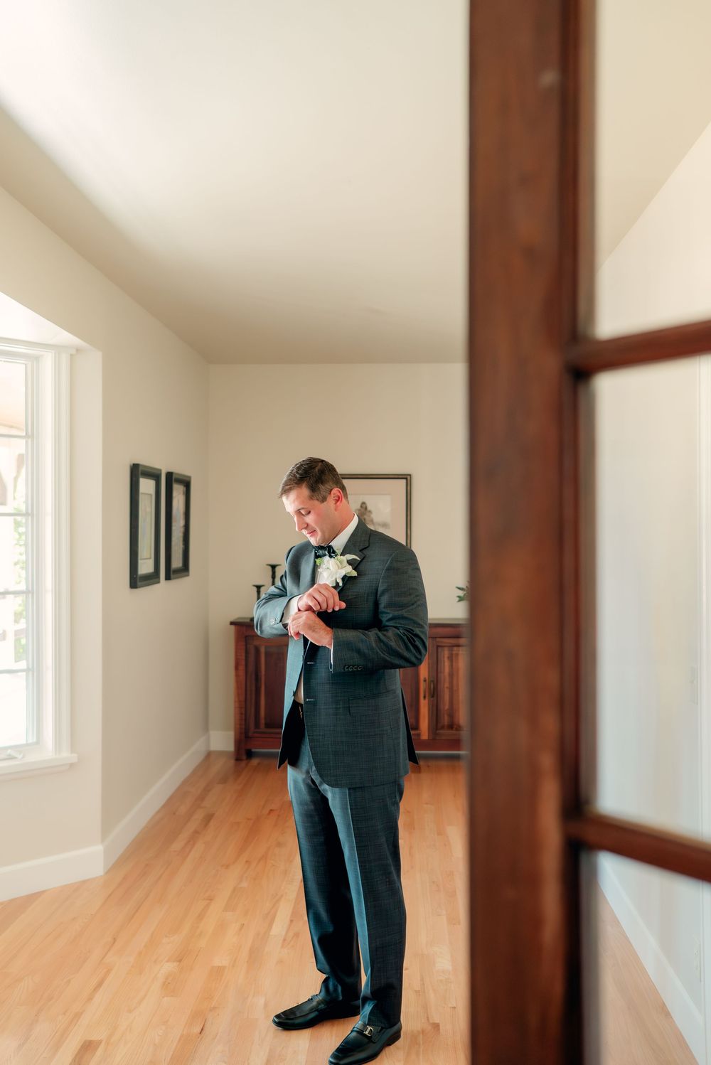An emotional moment captured in an empty room with hardwood floors and natural lighting through windows.