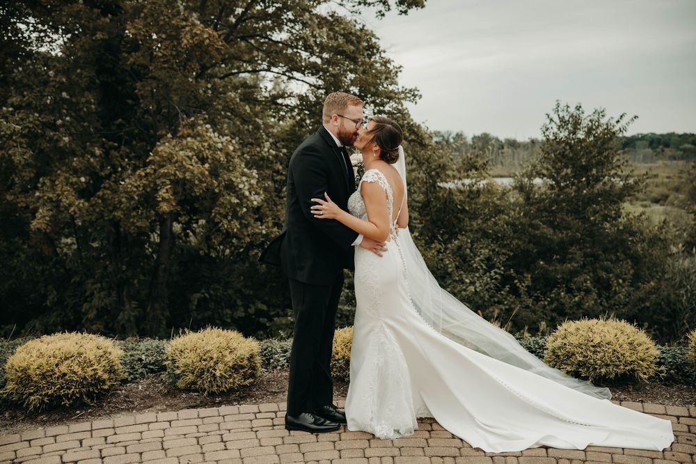 Bride and groom sharing romantic almost-kiss during outdoor wedding portraits in garden.