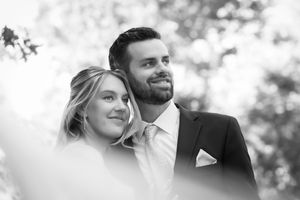 Black and white closeup image of bride and groom smiling looking away from camera