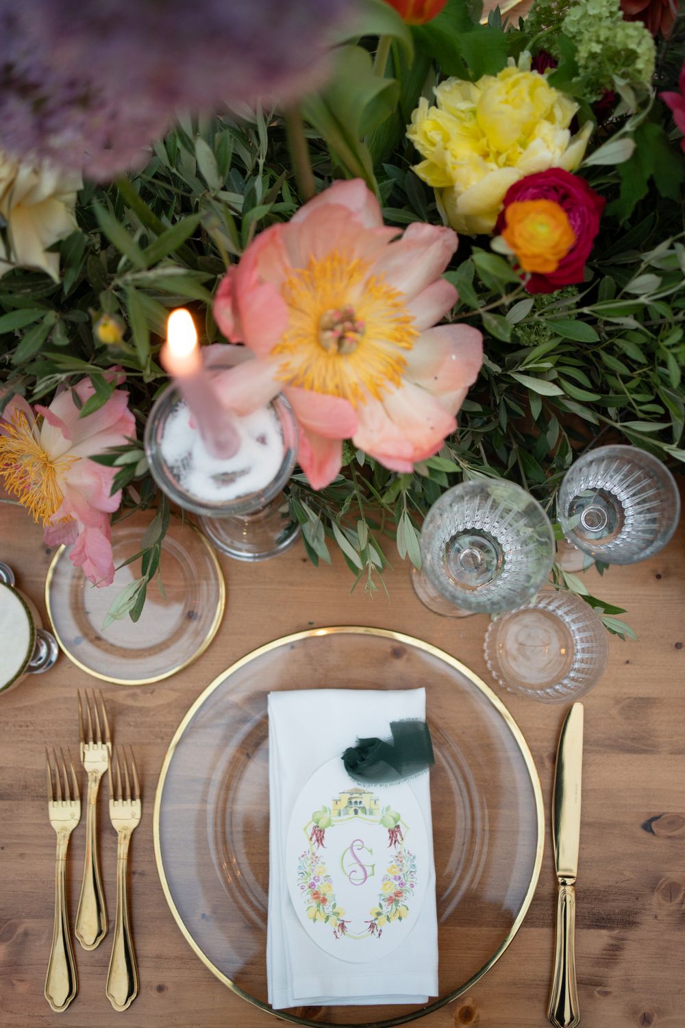 Elegant table settings with gold cutlery, crystal glasses, and floral accents on a rustic wooden surface create a romantic mood.