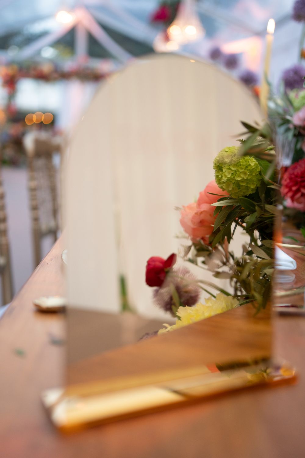 Close-up of wedding table decor with delicate floral arrangement and white place settings.