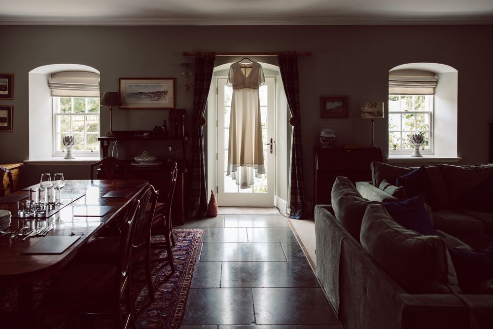 Dark and moody hallway with arched doorways and natural light streaming through windows creates dramatic atmosphere.