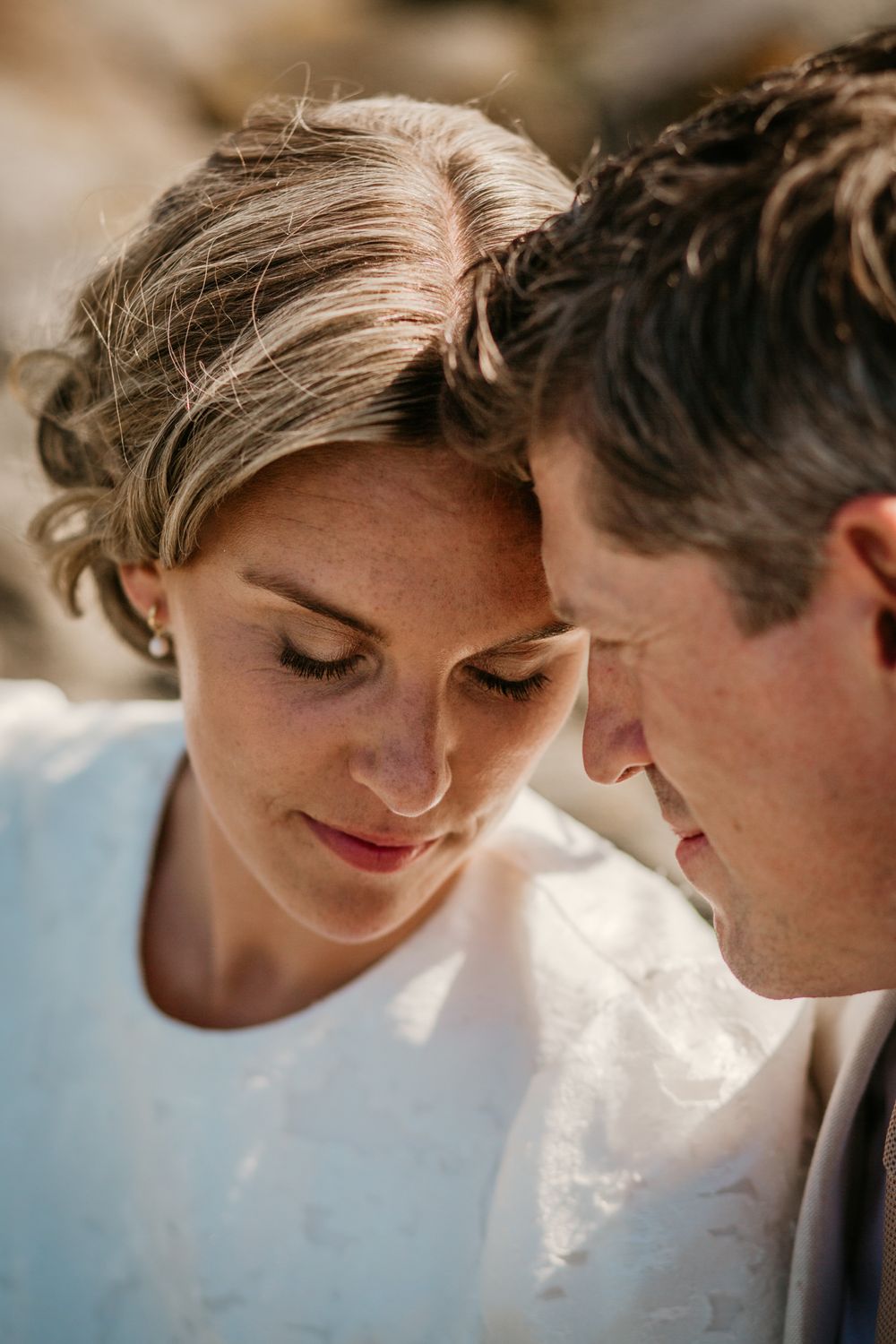 A romantic couple shares an intimate moment in soft natural lighting, their faces close together in a tender expression.