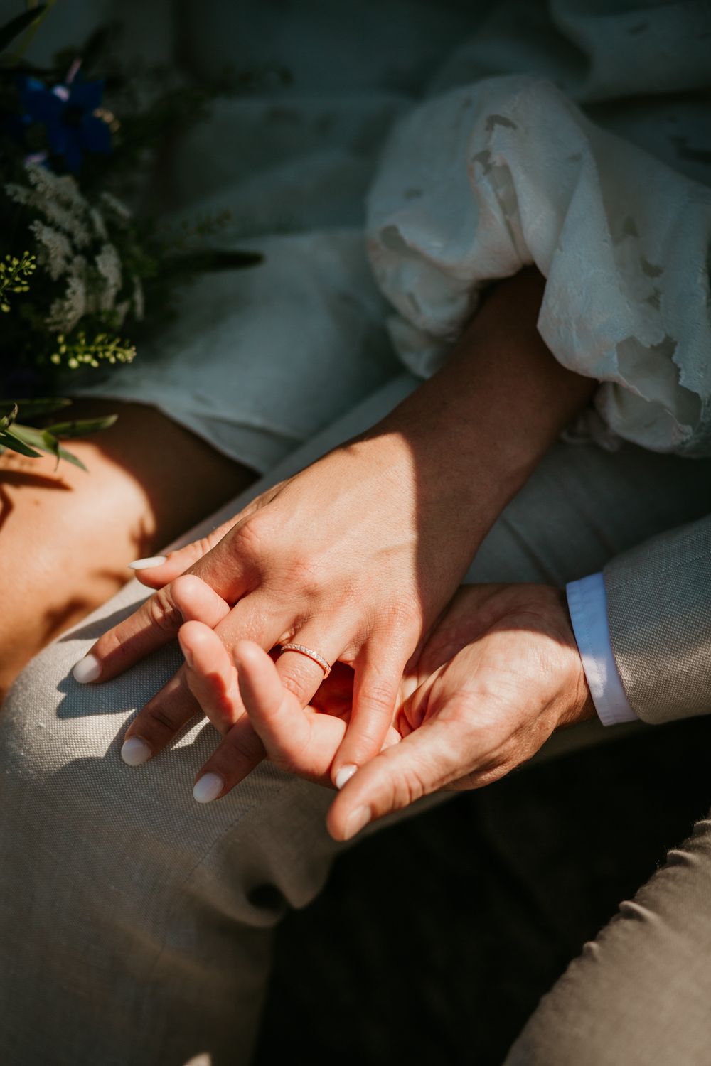 Close-up shot of hands exchanging wedding rings during an intimate ceremony.