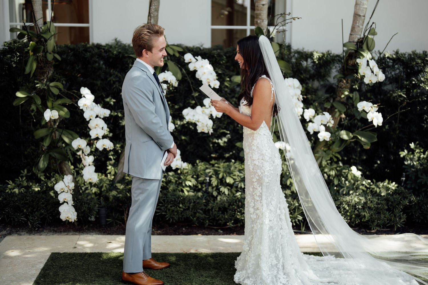 An elegant winter wedding reception features romantic white floral decor and candlelight in a grand venue setting.