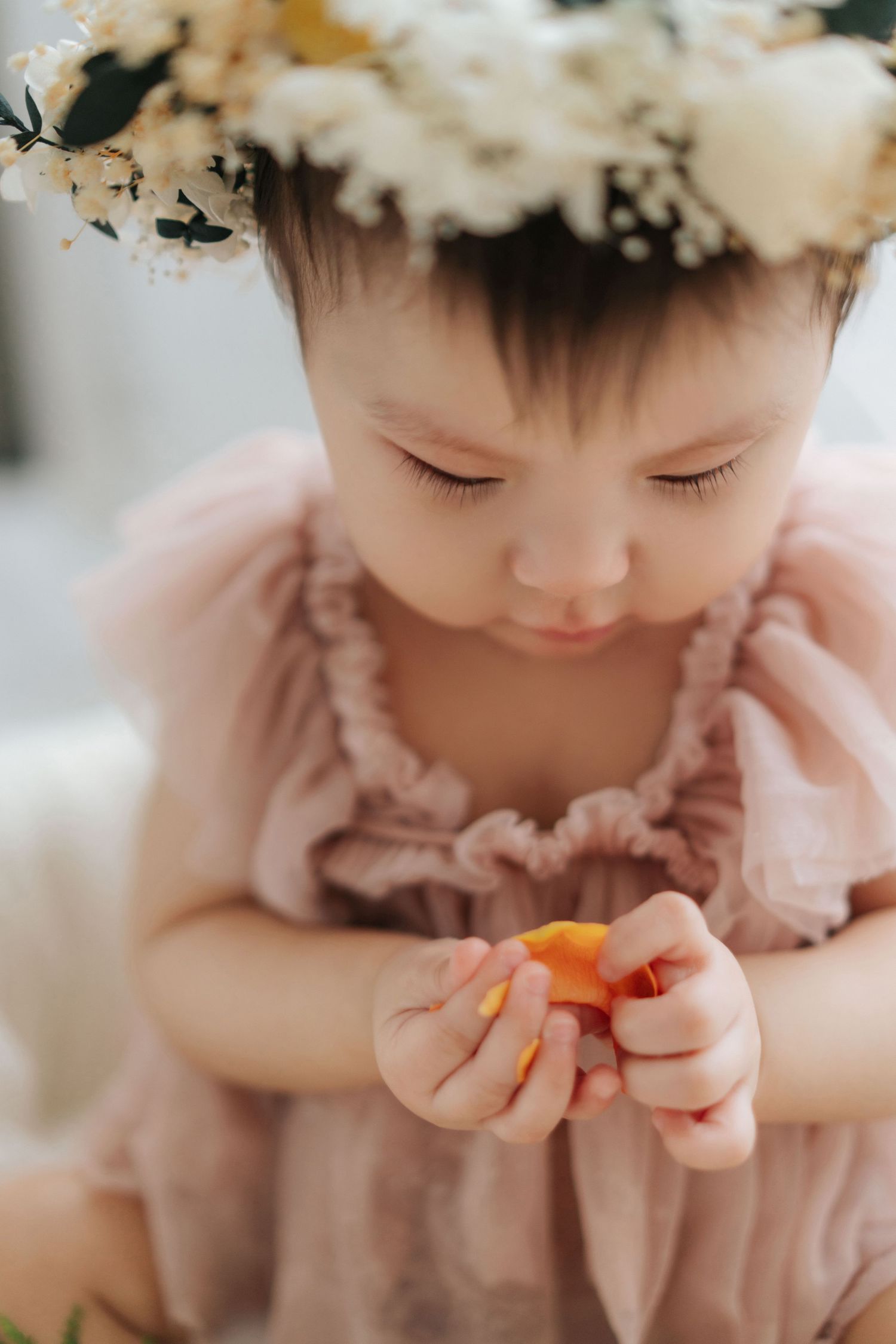A series of cake smash photos showing a baby in white outfit with blue cake and floral decorations in a bright studio setting.