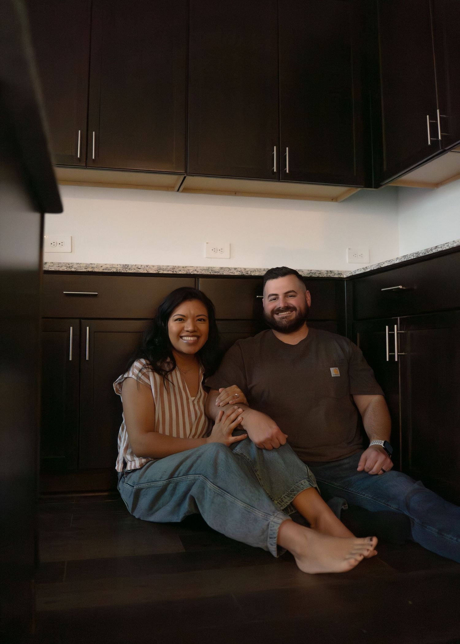 The Emerson Family of five posing in their empty new home, smiling and exploring their new space together