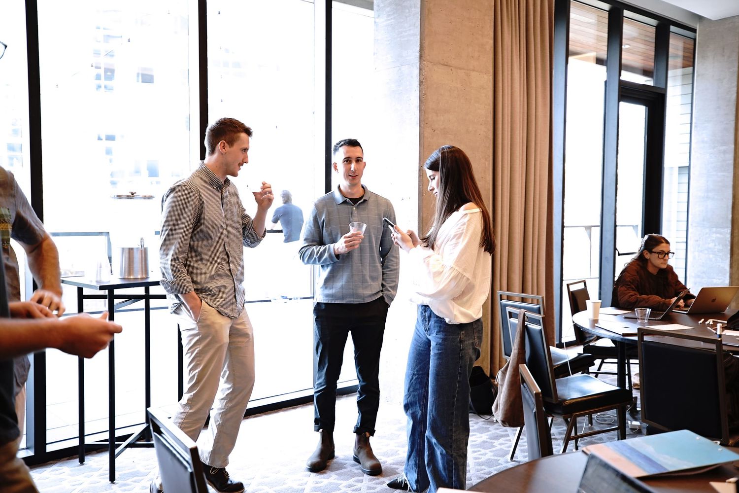 Casual business meeting with people conversing in modern office space.