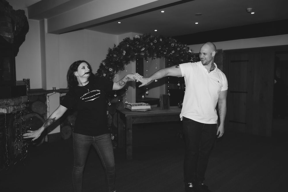 People dancing and socializing at a dimly lit indoor event venue.