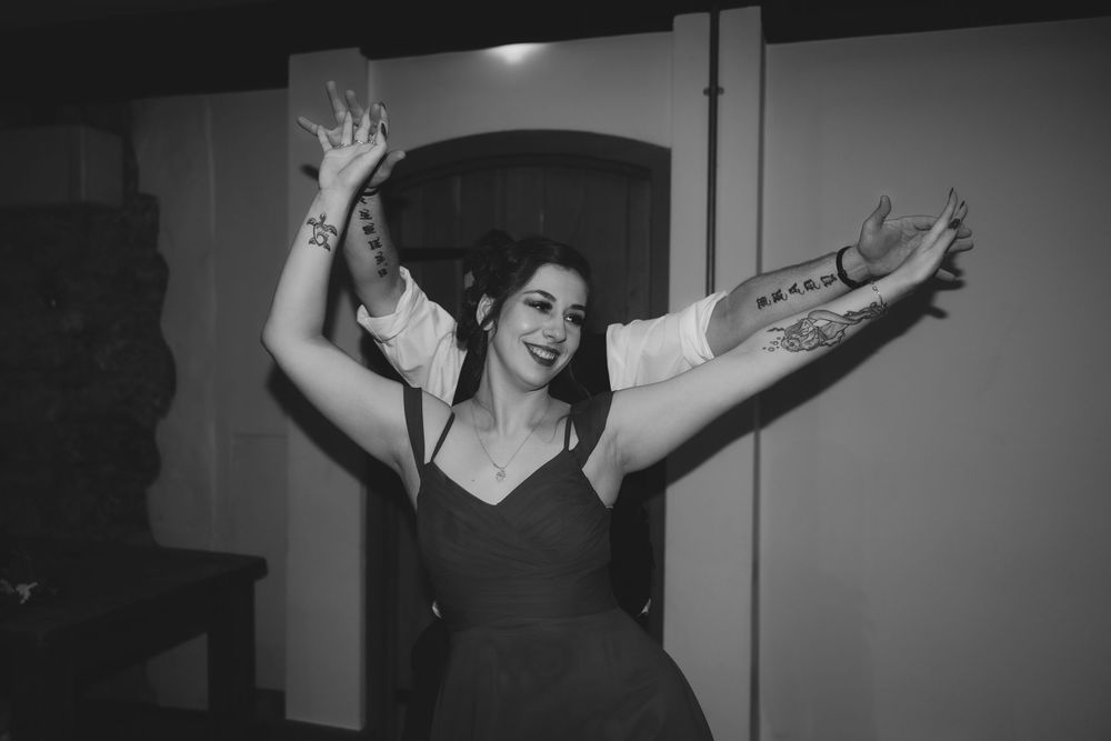 A sequence of black and white photos showing a person dancing and expressing joy with raised arms.