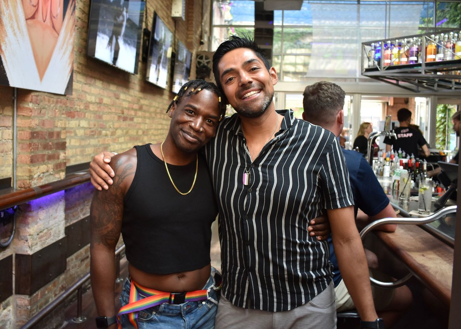 Two football players smile for the camera at the opening party event of Pride Bowl in Chicago hosted by CMSA