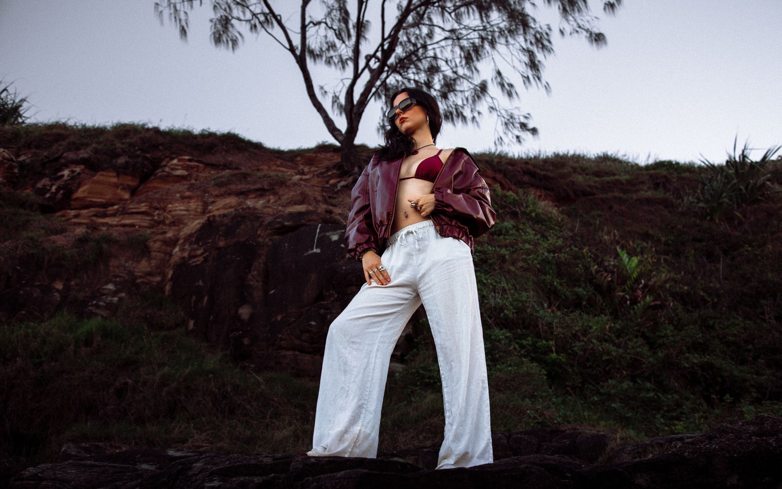Stylish outfit captured against red rocks and foliage at dusk.