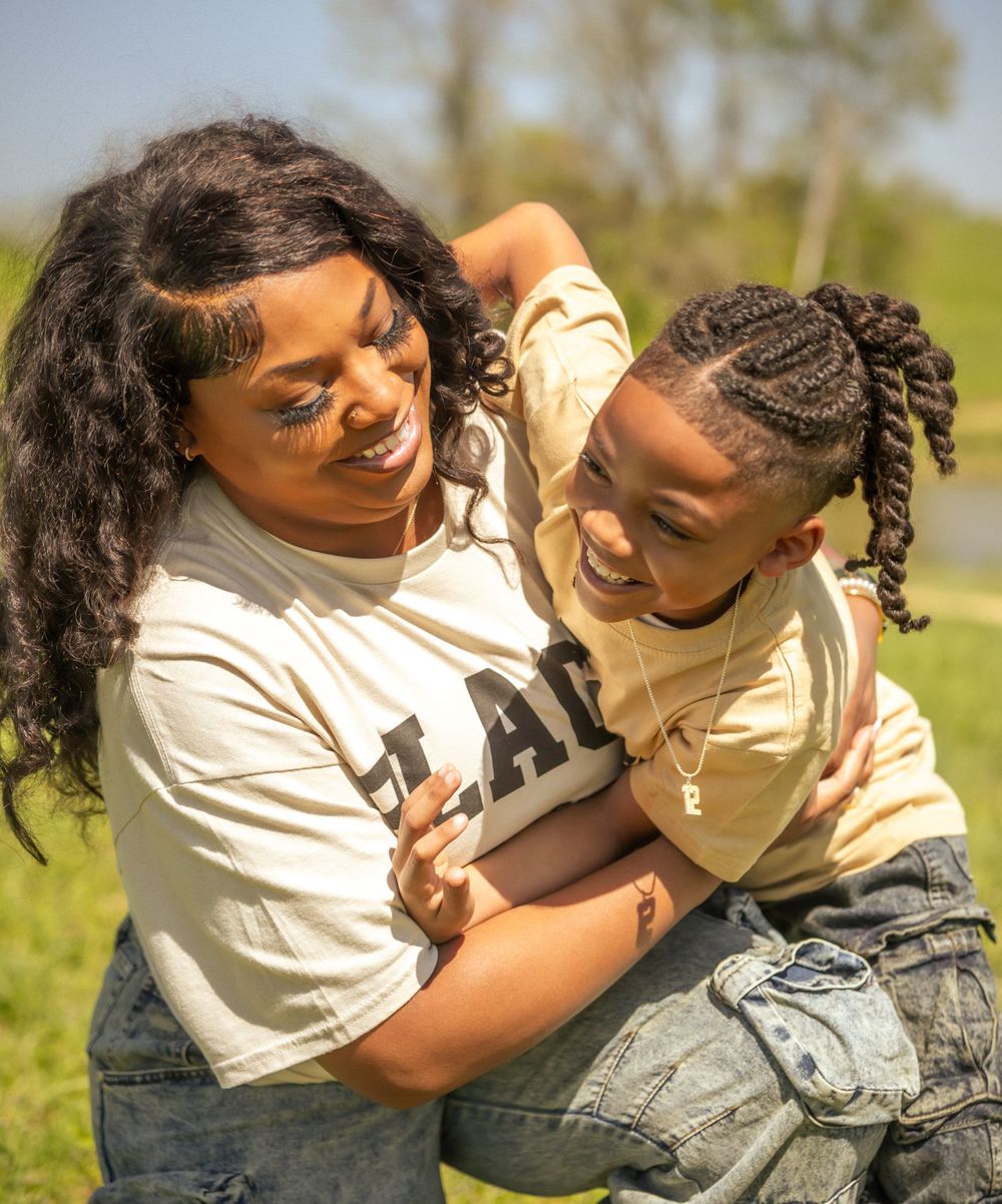 An intimate embrace captures playful affection and bonding during a sunny outdoor photoshoot.