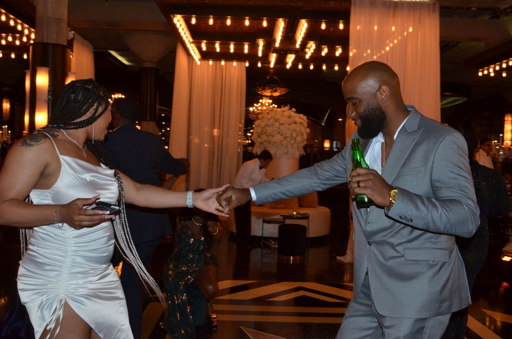 Guests dancing and having fun at a reception with atmospheric lighting.