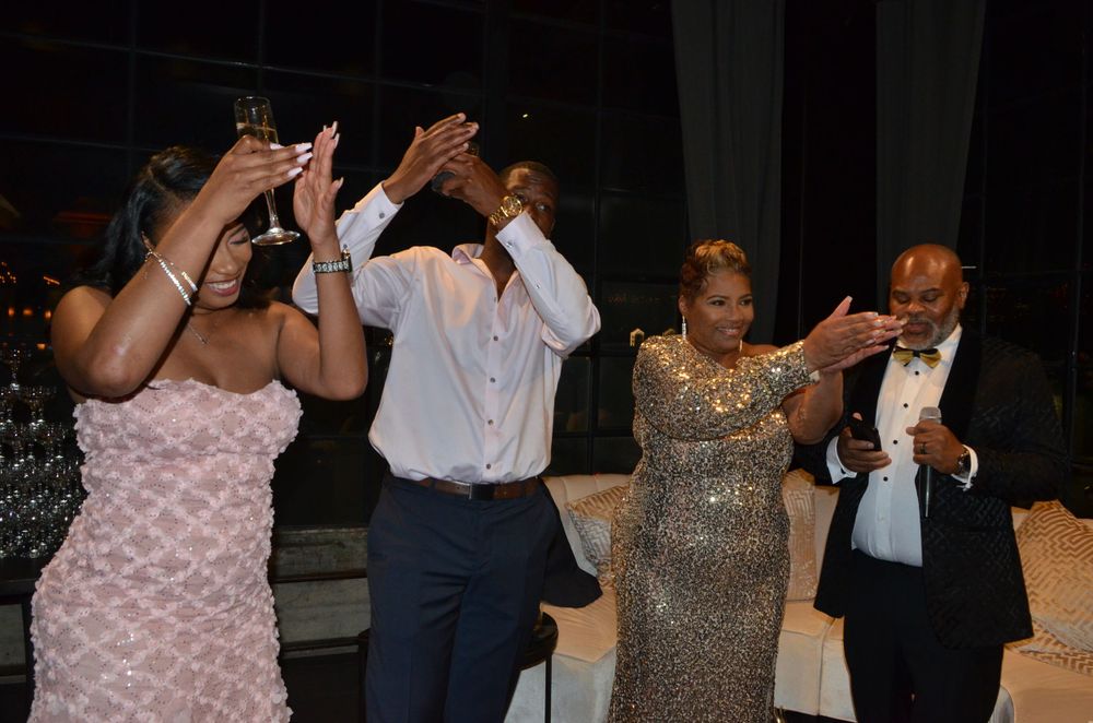 People raising their hands in celebration during a lively party moment.