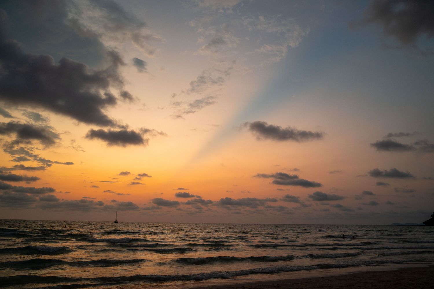 Panoramic sunset view over ocean with dramatic clouds and colorful sky.