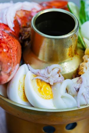 Close-up series of egg and tomato slices arranged around a circular dish with dipping sauce in the center.