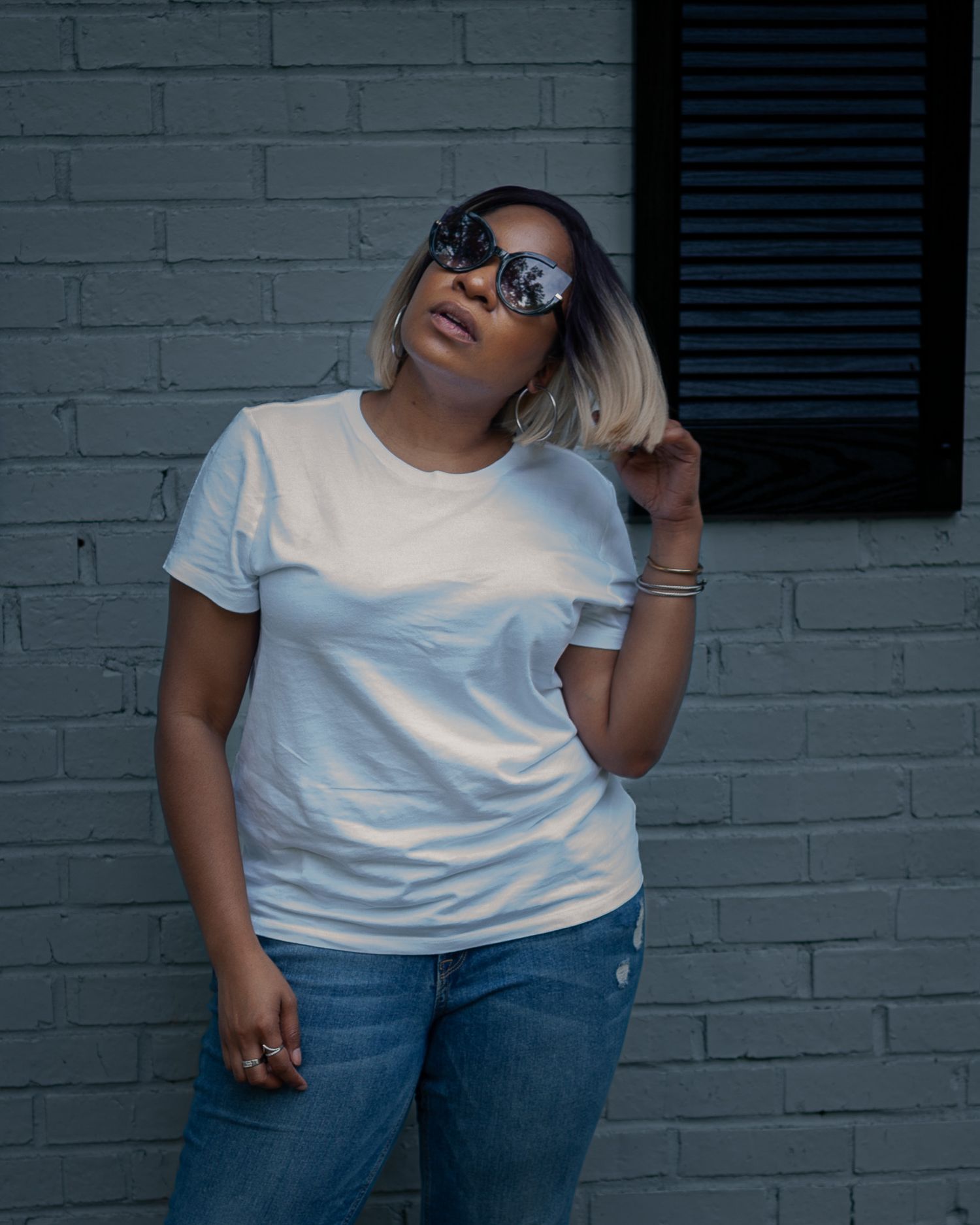 Casual street style portrait against gray brick wall with sunglasses and white t-shirt. Lifestyle photography, San Diego, California