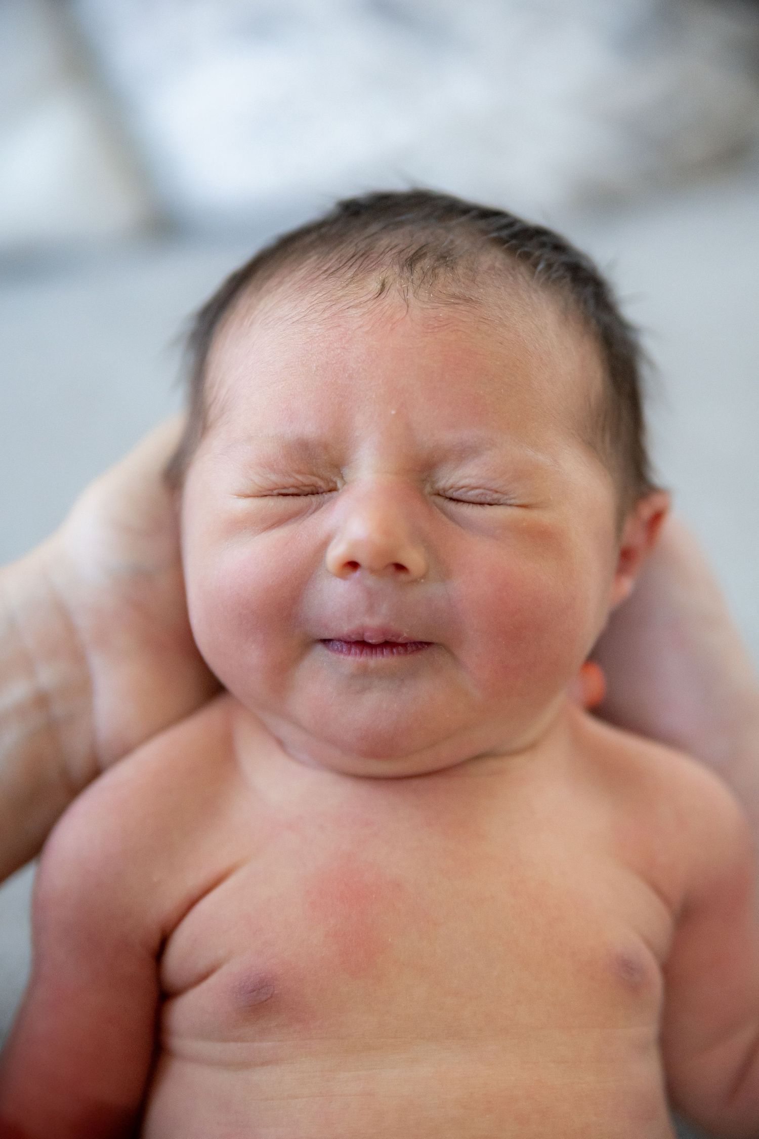 Series of peaceful sleeping baby expressions showing different smiles and facial features in a heart-warming close-up.