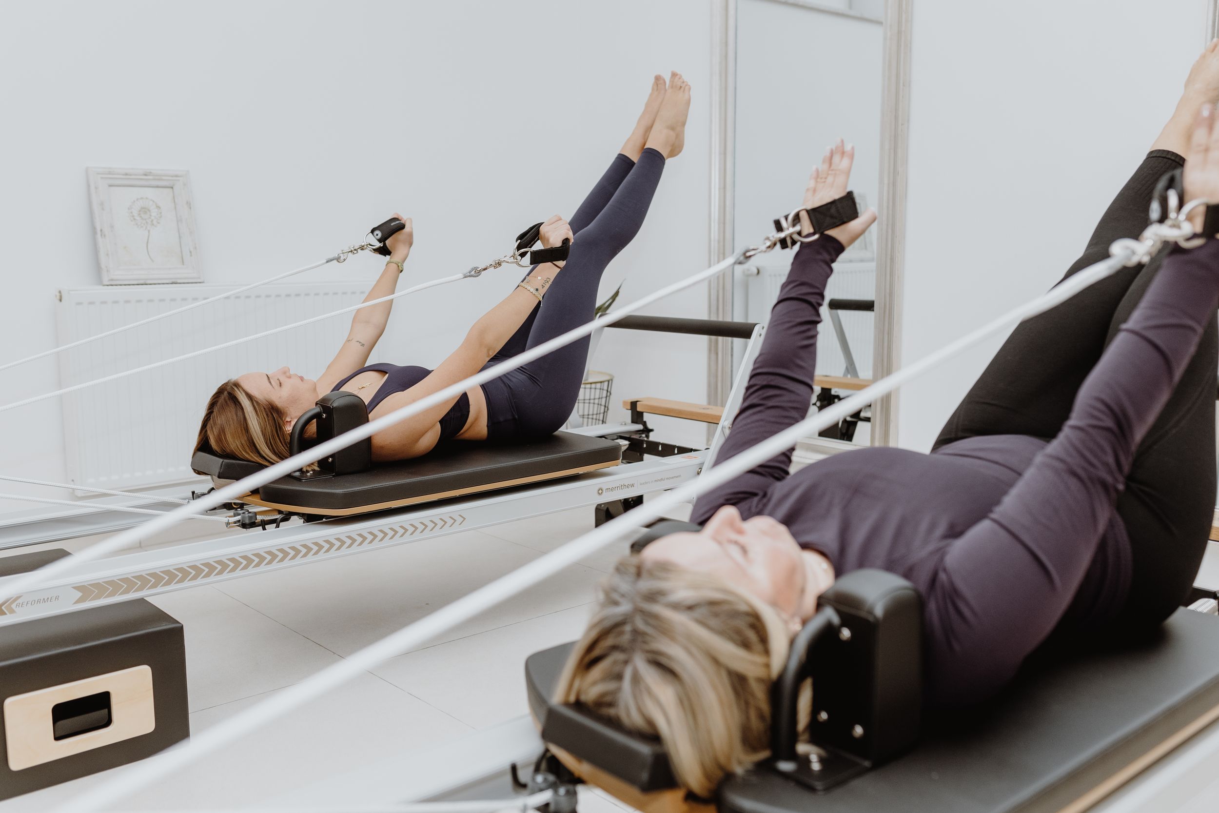 Pilates routine on reformer equipment, styled as brand photography to showcase coordinate movements in a Zagreb studio.
