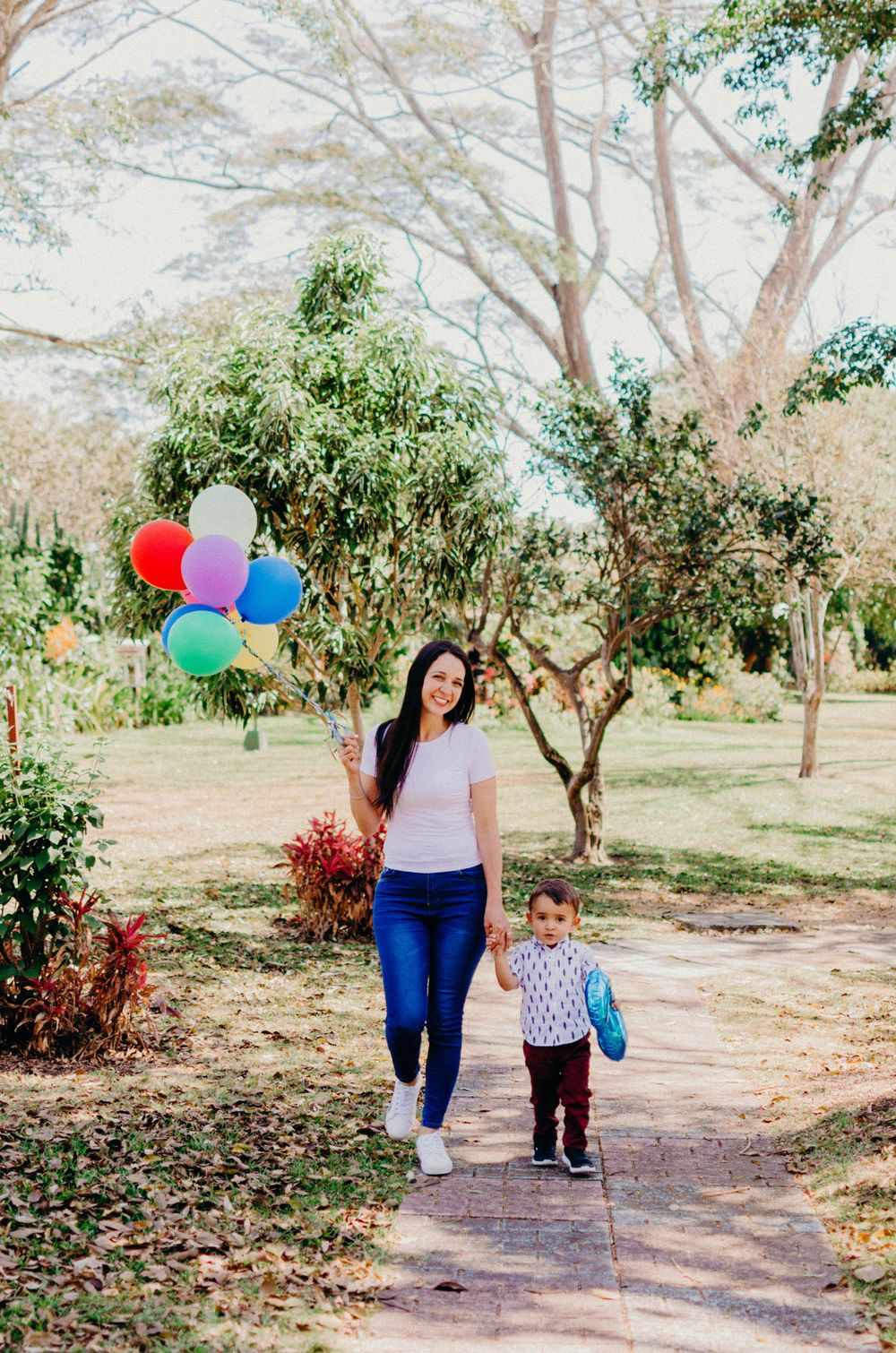 A peaceful garden walk with colorful balloons adding festive cheer to the natural setting.