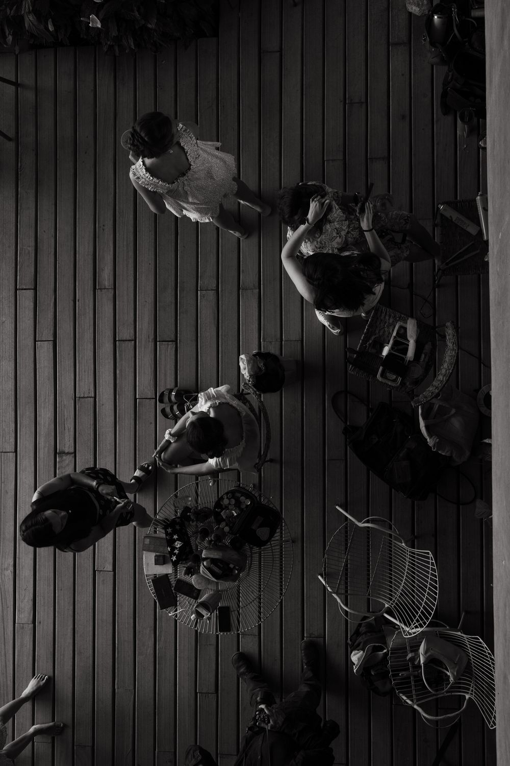 Aerial black and white photo of people gathered on a wooden deck viewed from above.