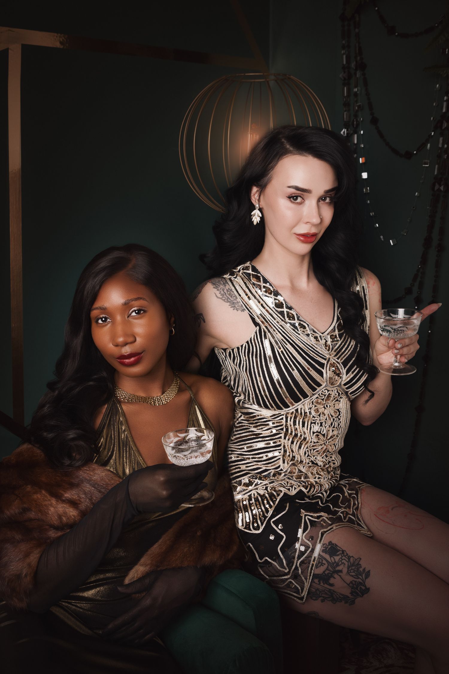 Two elegantly dressed women holding cocktails in a glamorous Art Deco-inspired setting with gold accents.
