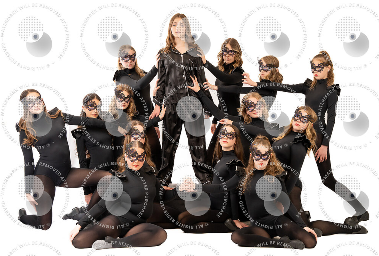 Group of dancers in black costumes and masquerade masks posing together for a studio dance team portrait photo.