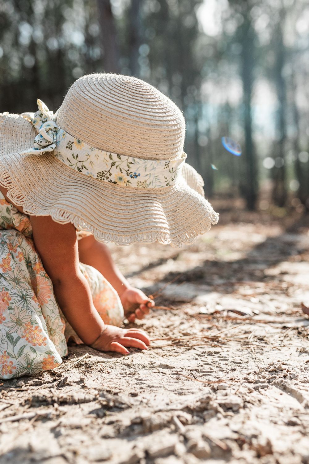 child in hat playing in dirt