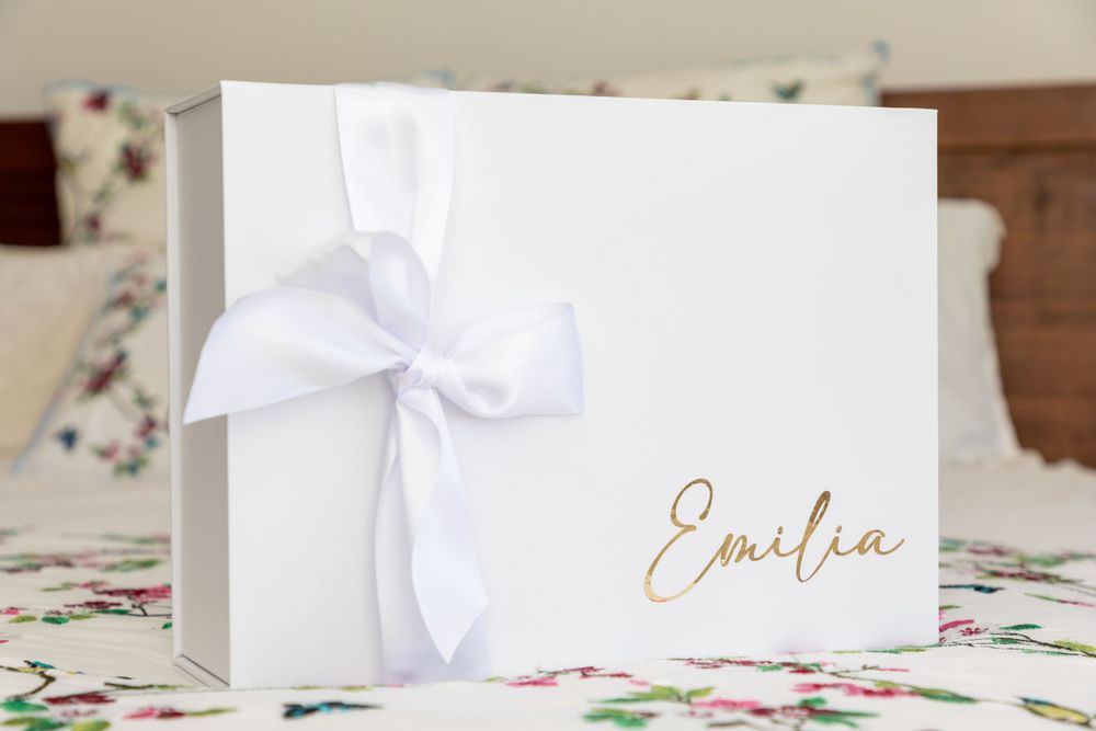 baby on christening box with mother and father and godmother