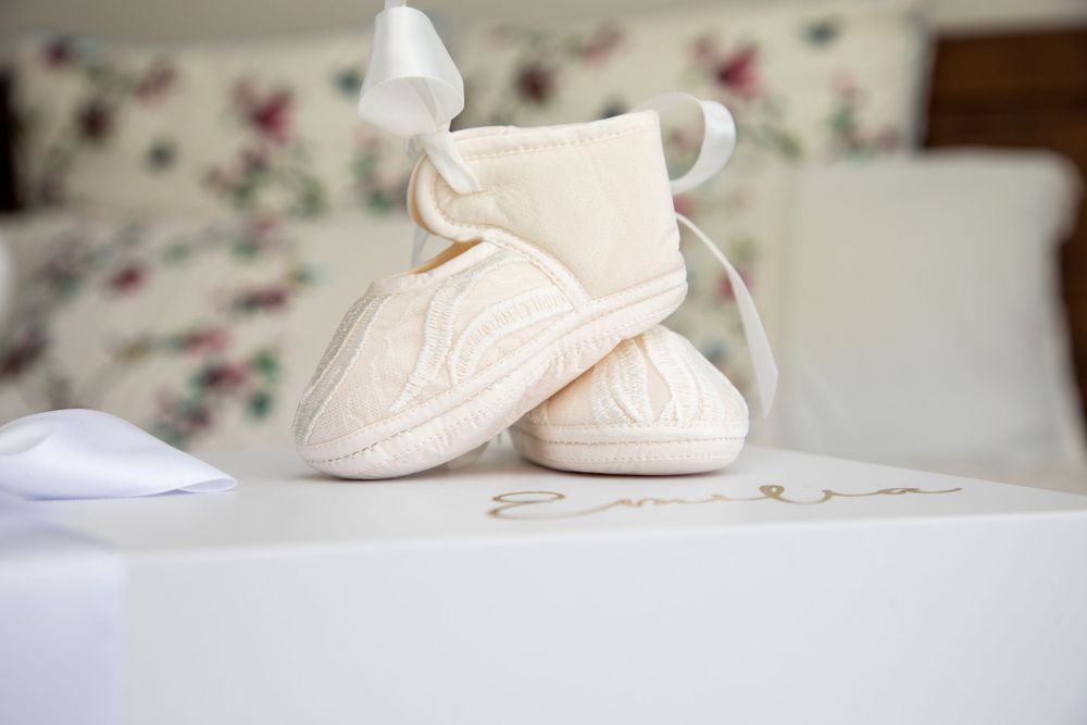baby on christening shoeswith mother and father and godmother