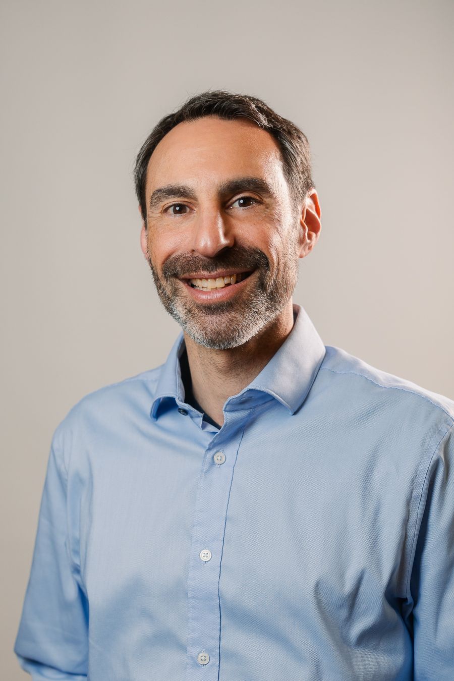 Smiling man in light shirt and blazer, Miami professional headshot by Mannyportraits, ideal for corporate LinkedIn.