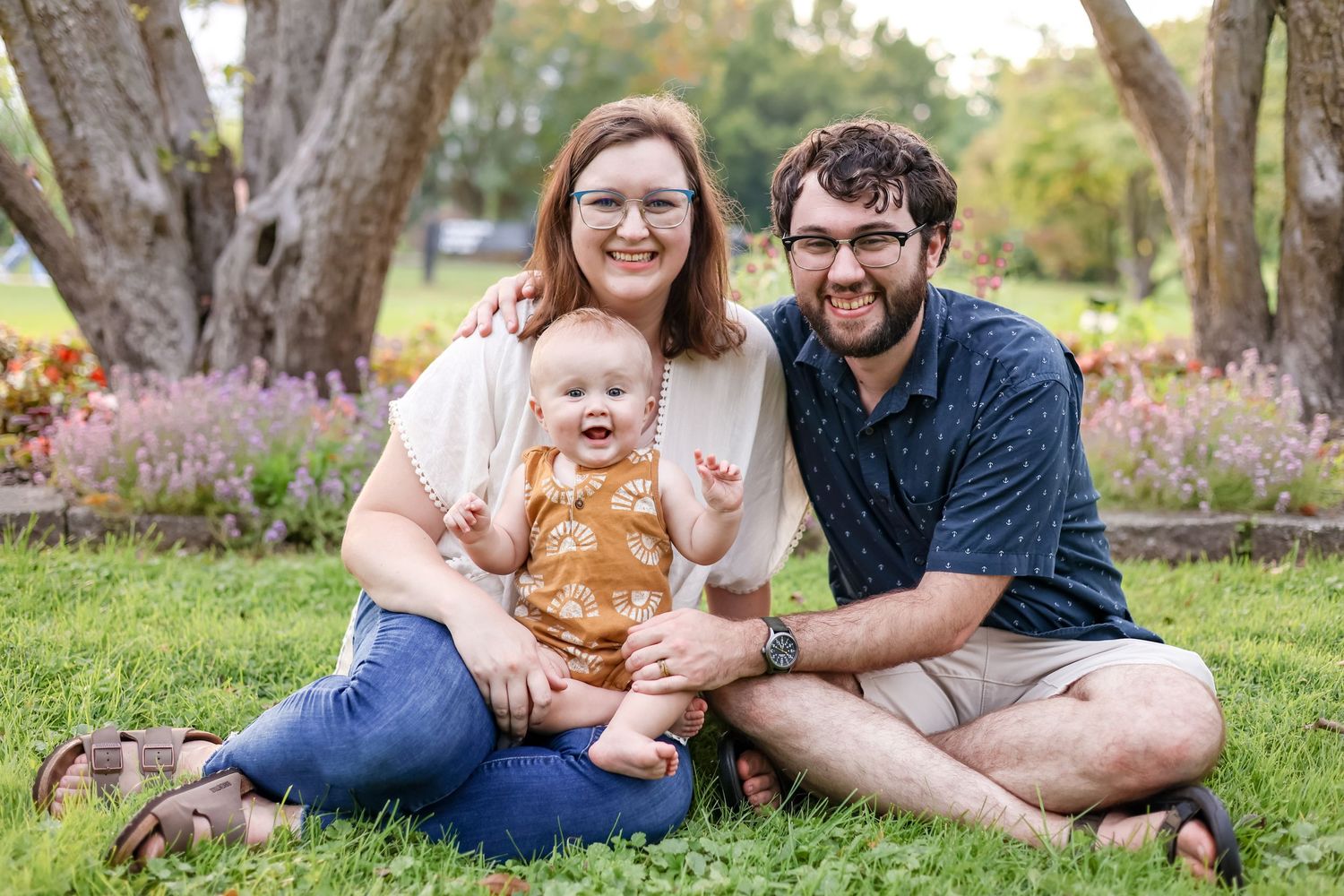 Springfield, IL family photographer photographs a family sitting together around flowers at Washington Park Botanical Garden in Central, IL