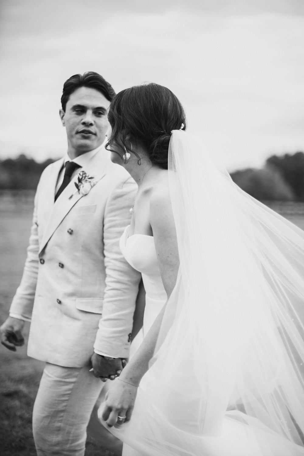 Black and white portrait of a couple in elegant wedding attire standing in an outdoor setting at the Lightfoot & Wolfville wedding venue