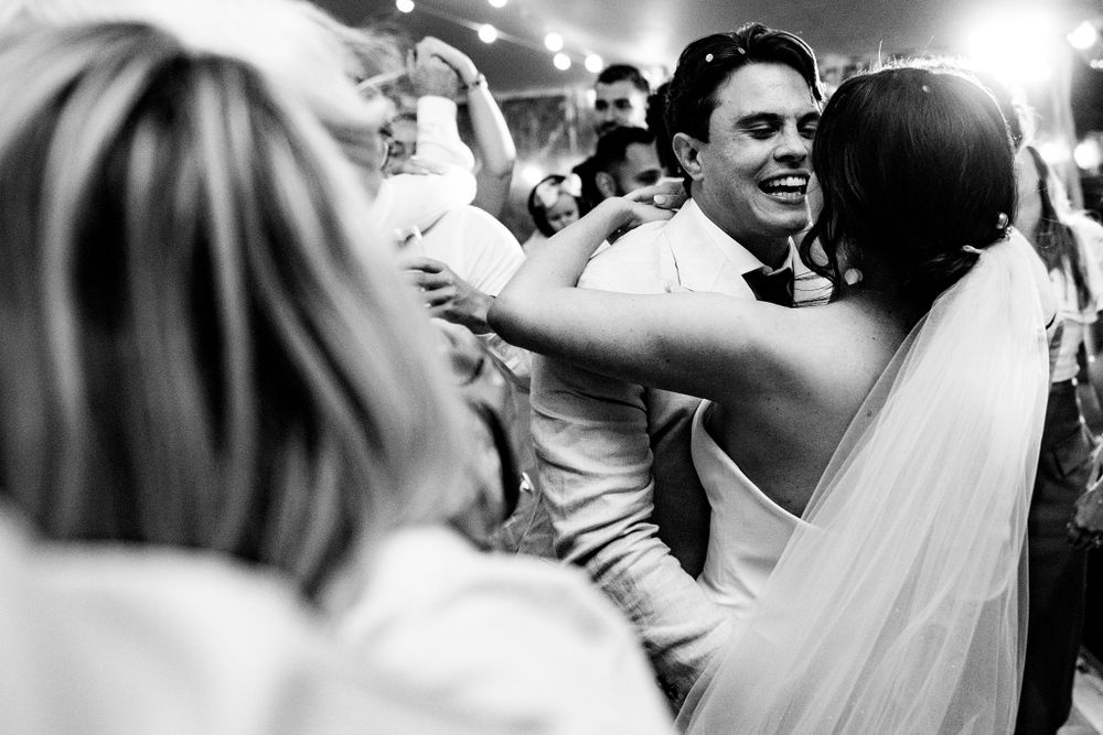 Black and white photo of newlyweds celebrating with guests on dance floor at the Lightfoot & Wolfville wedding venue.