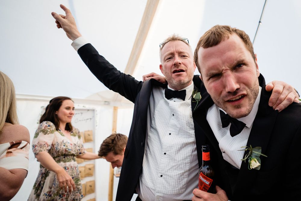 Candid reception party moment with guests celebrating and dancing in a wedding tent at the Lightfoot & Wolfville wedding venue