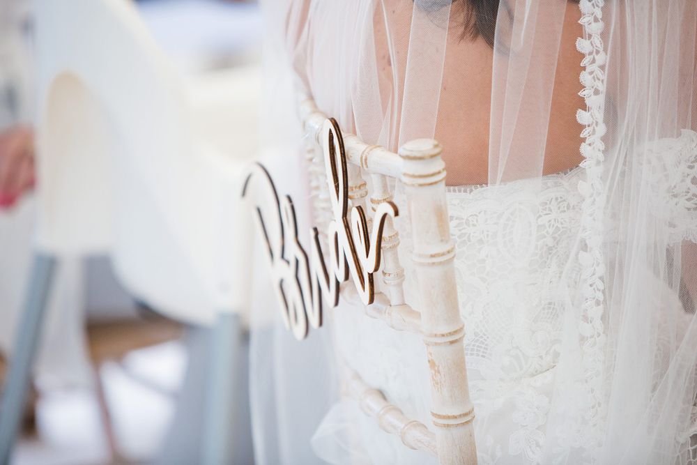 Close-up detail of white wedding decor featuring a 'Mr & Mrs' chair sign and delicate lace veil at at the Lightfoot & Wolfville wedding.