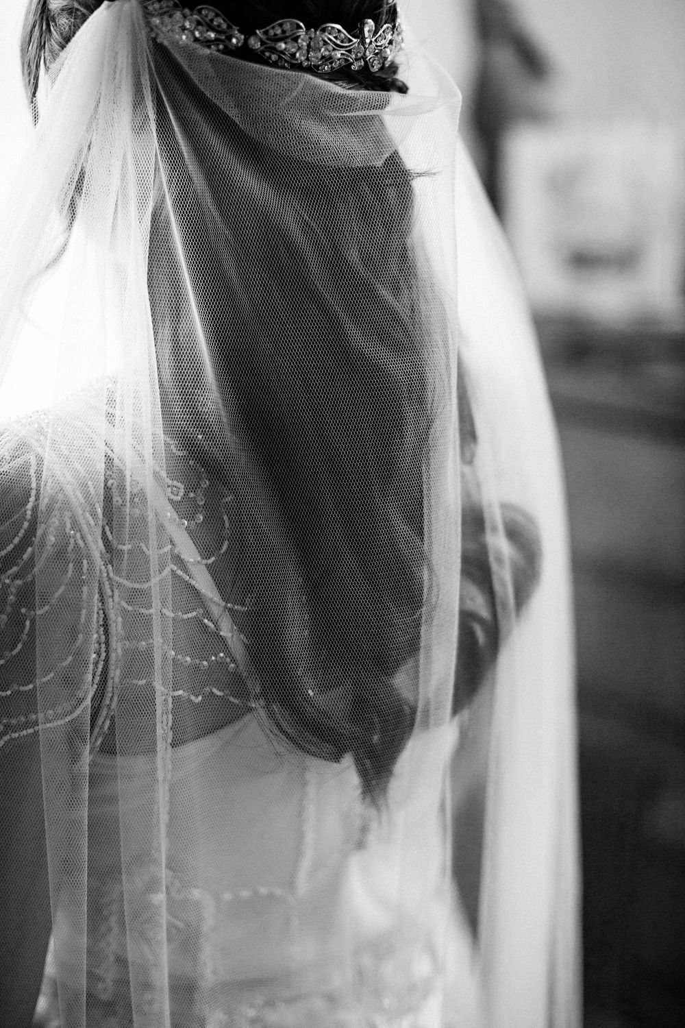 Black and white detail of a delicate bridal veil with an ornate crown headpiece at the Lightfoot & Wolfville wedding venue