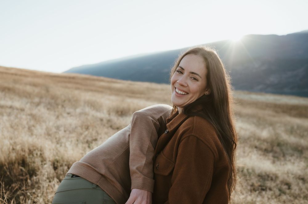 Candid laughter in golden mountain meadow during sunset.