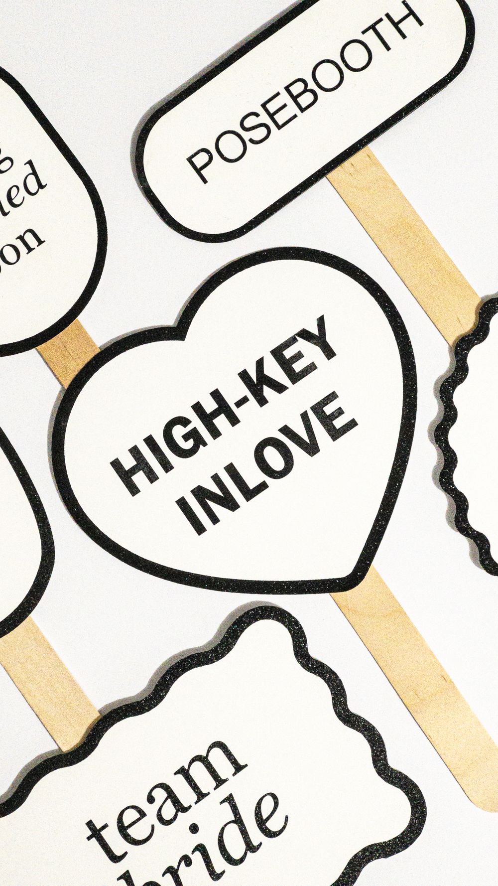 Close-up of photo booth prop with 'HIGH-KEY INLOVE' text in heart shape on golden stick. Perth WA Photo booth Hire Event Booth