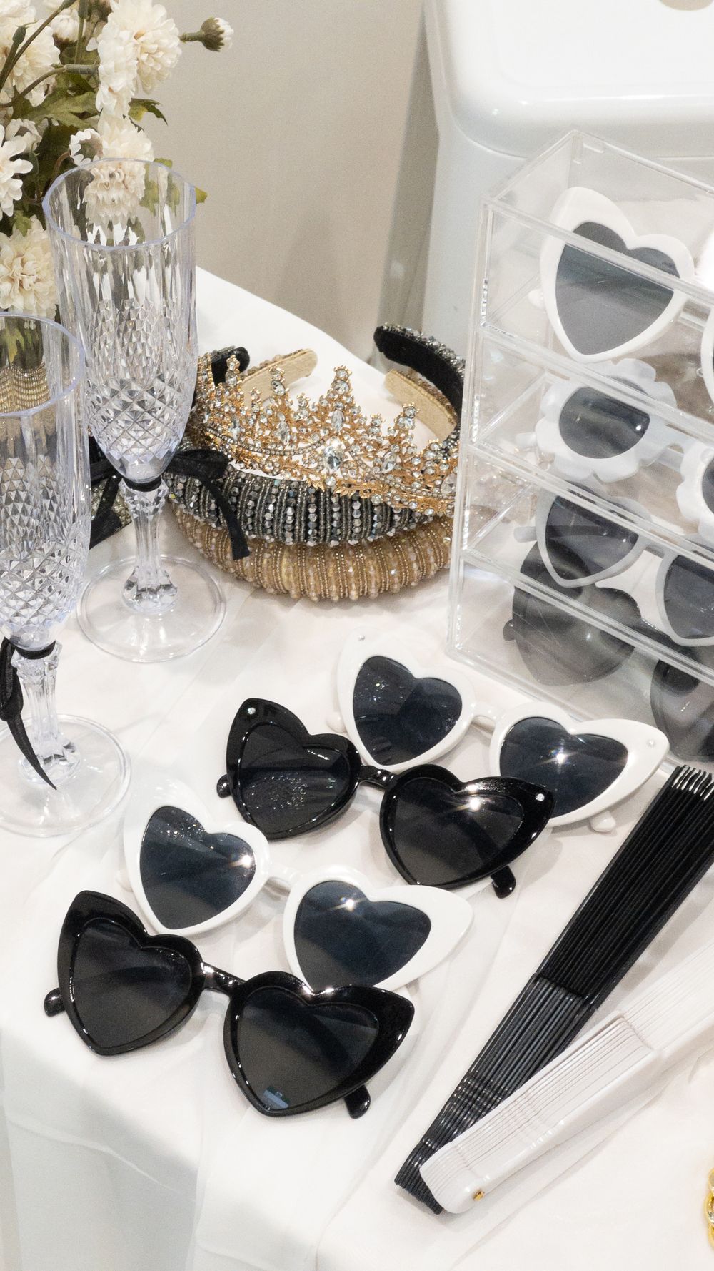 Elegant party setup with heart-shaped sunglasses, crystal champagne flutes, and decorative tiaras. Perth WA Photo booth Hire Event Booth