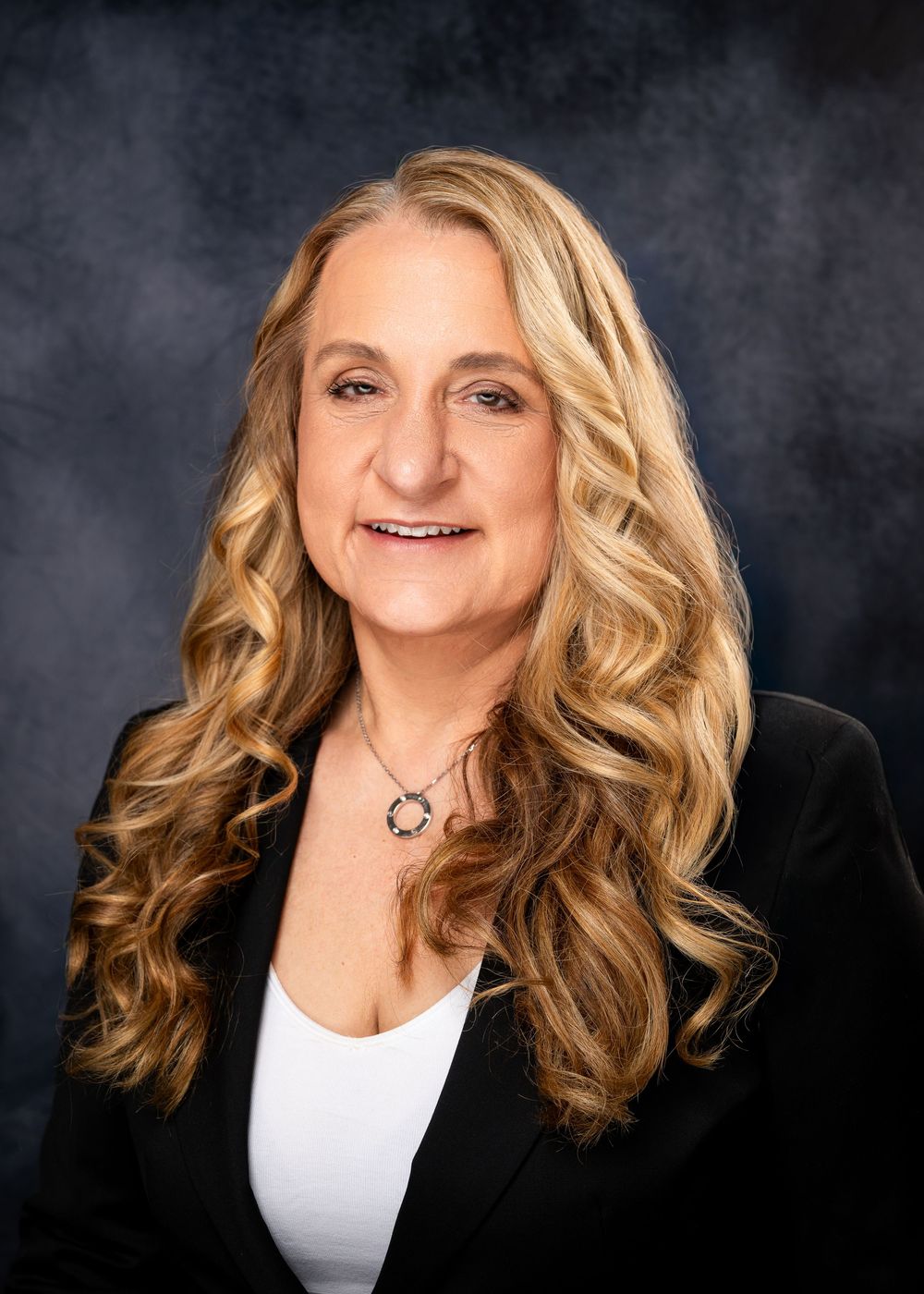Professional headshots showing a woman with wavy blonde hair in a black blazer against a dark background.