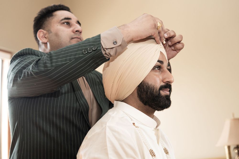 A traditional Sikh turban being tied during wedding preparation.
