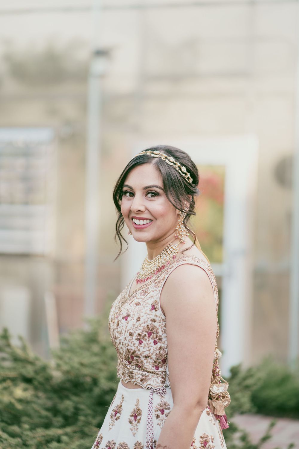 A beautiful bridal portrait showcasing an ornate white and gold gown with delicate hair accessories.