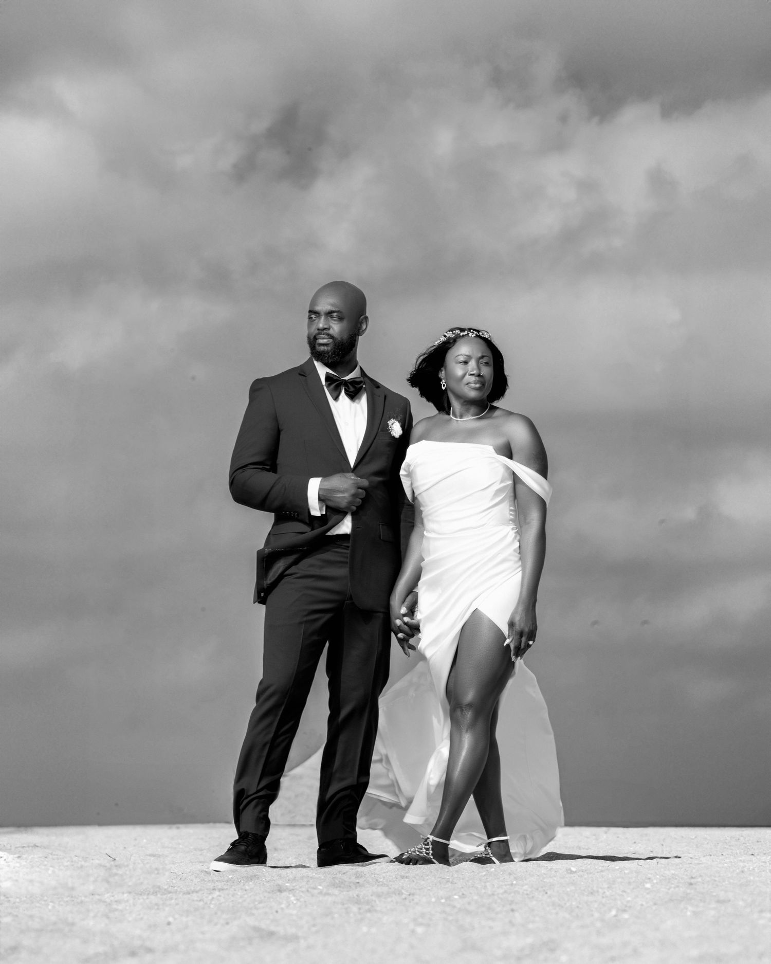Dramatic black and white beach portrait with stormy sky background.
