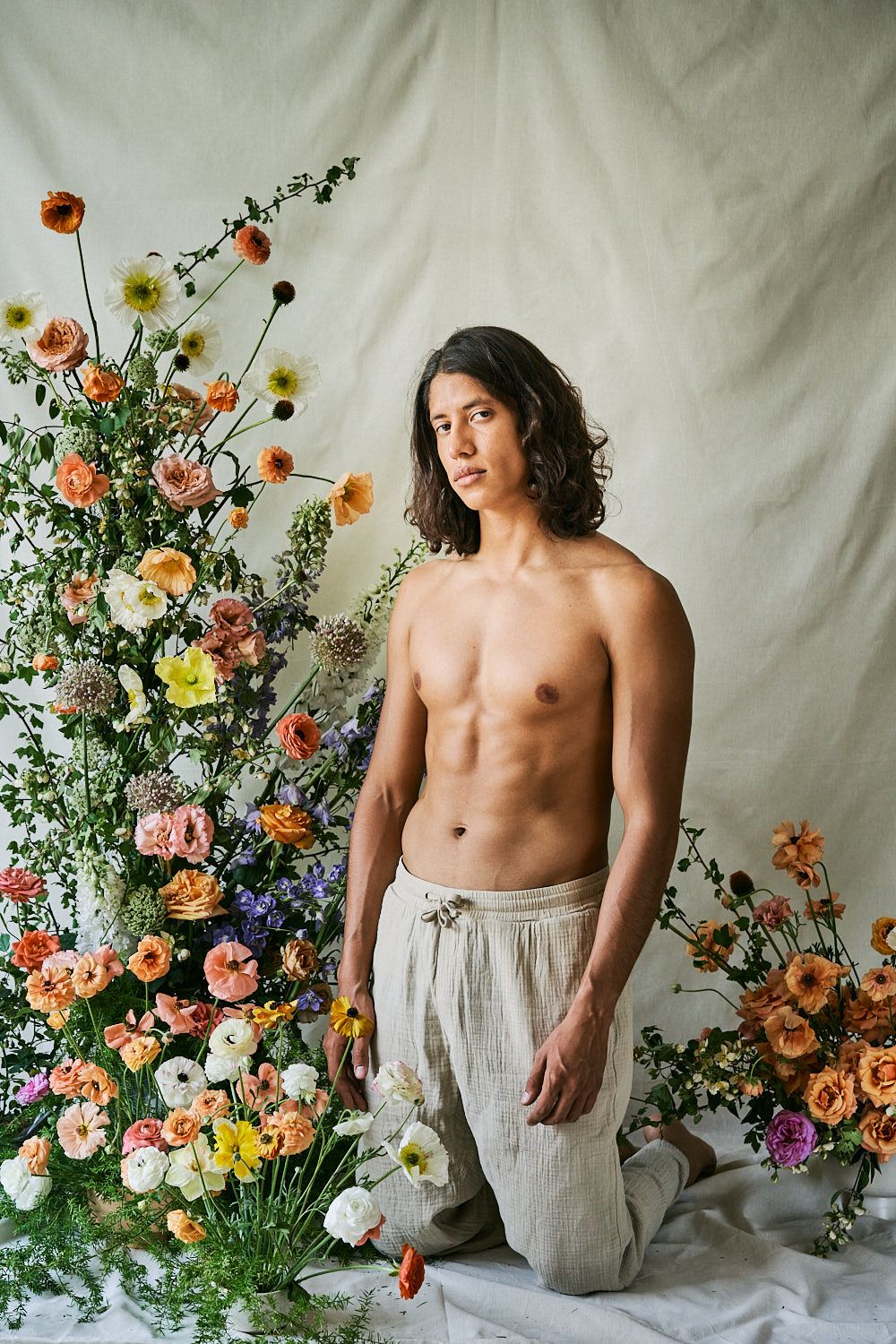 Artistic portrait with floral arrangement featuring colorful spring blooms and natural styling.