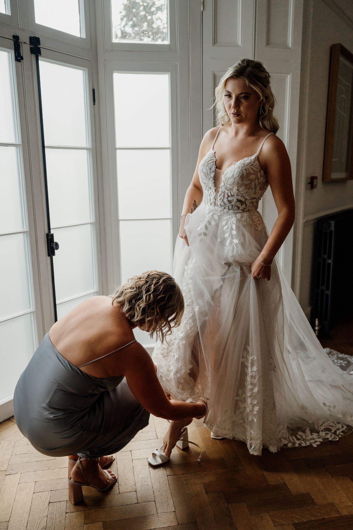 Behind-the-scenes wedding preparation moments in a bright, sunlit room with hardwood floors.