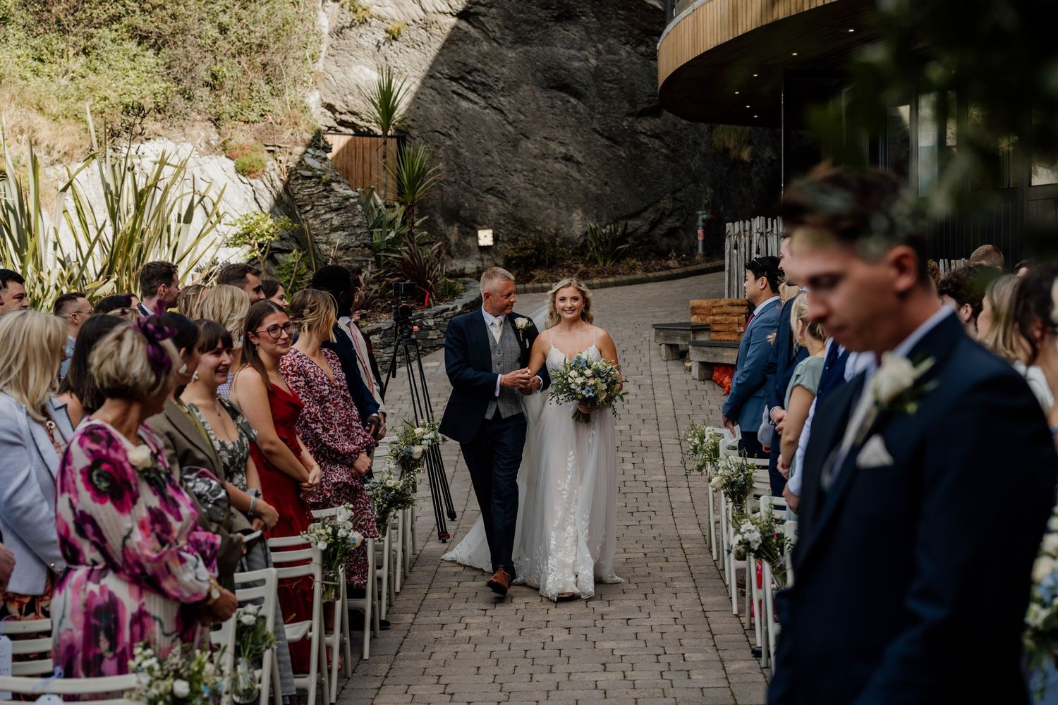 Guests seated for an intimate outdoor wedding ceremony surrounded by natural greenery.