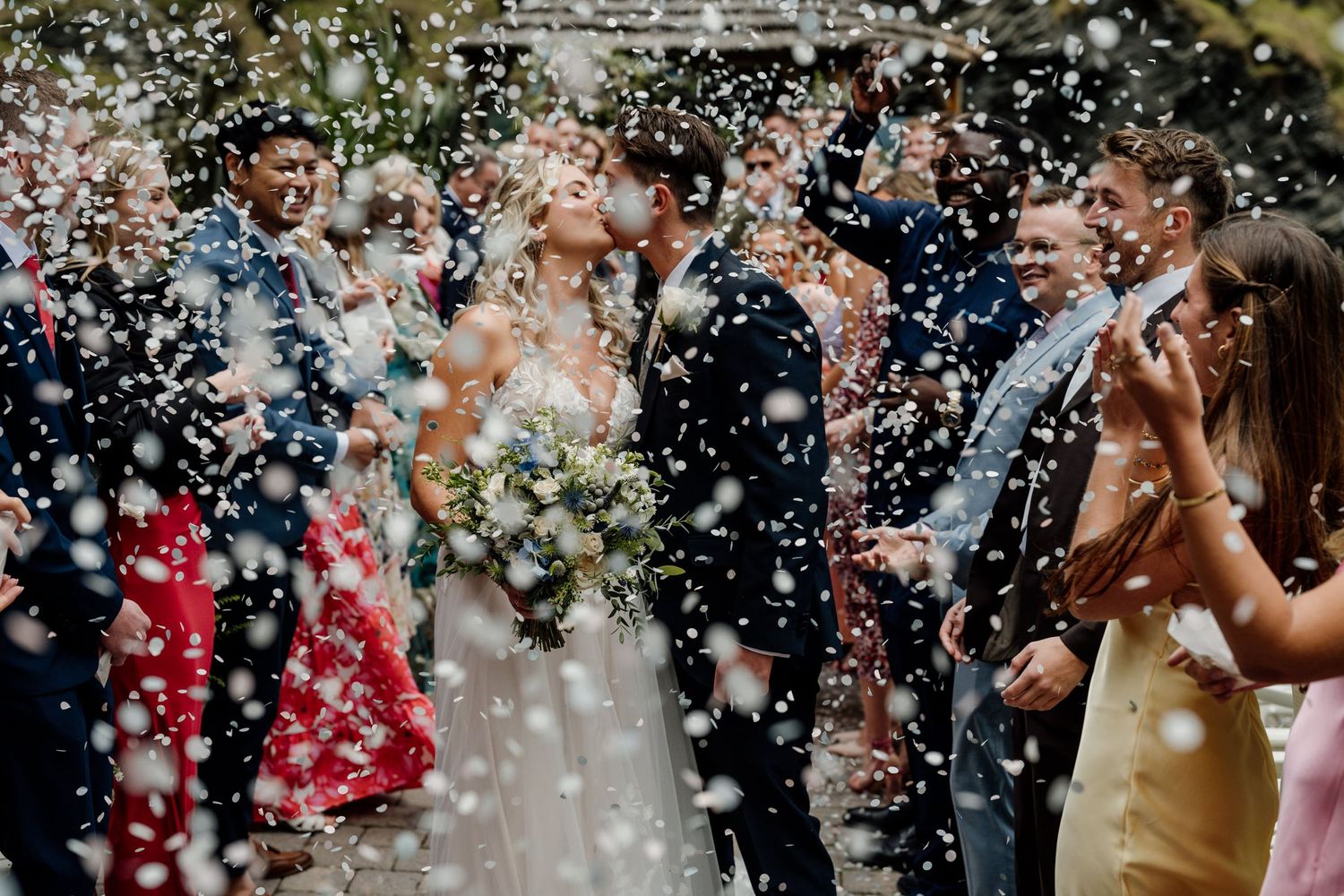 Joyful celebration with confetti being thrown in the air during wedding festivities.
